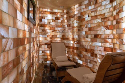 a room with a wooden wall and two chairs at Swiss Diamond Hotel Prishtina in Pristina
