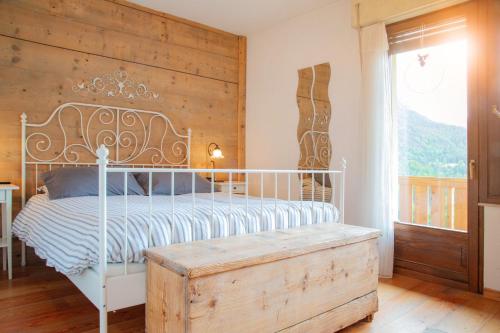 a bedroom with a white bed and a wooden wall at Casa Fiore CIPAT 22038 in Canale San Bovo