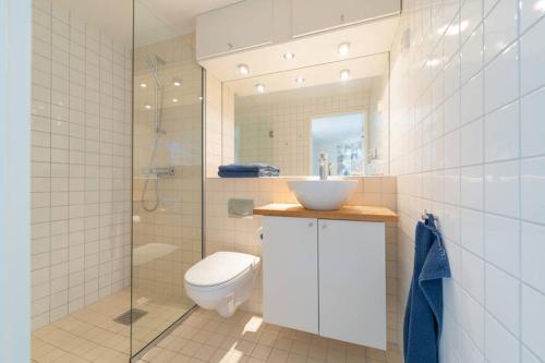 e bagno con servizi igienici, lavandino e doccia. di Nordic Host Luxury Apts - Prinsens Gate - Large Mezzanine Studio a Oslo
