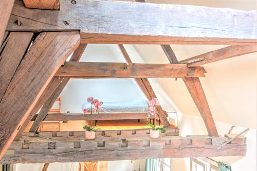 a large wooden beam in a room with potted plants at Tempel Cathedral Lodge in the Heart of Antwerp in Antwerp