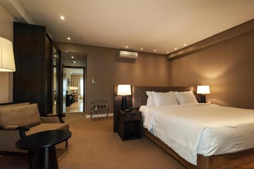 sypialnia z dużym białym łóżkiem i krzesłem w obiekcie Radisson Hotel Anápolis w mieście Anápolis