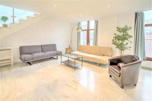 a living room with a couch and a chair at The Antwerp Marble Lodge in Antwerp