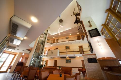 a dining room with tables and chairs in a building at Kehida Termál Resort & Spa in Kehidakustány
