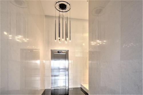 a hallway with a elevator with a clock on the wall at The Antwerp Marble Lodge in Antwerp