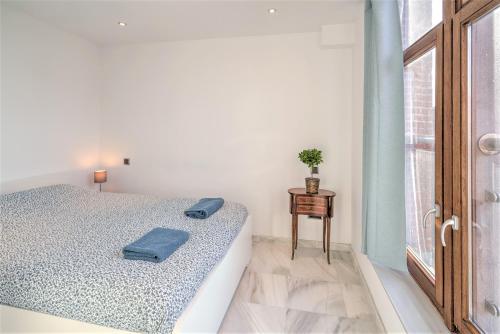 a white bedroom with a bed and a window at The Antwerp Marble Lodge in Antwerp