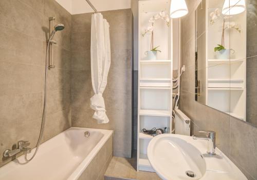 een badkamer met een bad, een wastafel en een douche bij The National Lodge in Antwerpen