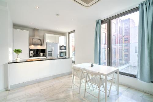 a white kitchen with a table and a large window at The Antwerp Marble Lodge in Antwerp