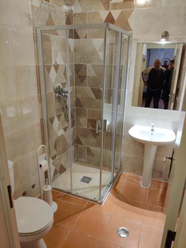 een badkamer met een douche, een toilet en een wastafel bij Casas do Megué in Évora