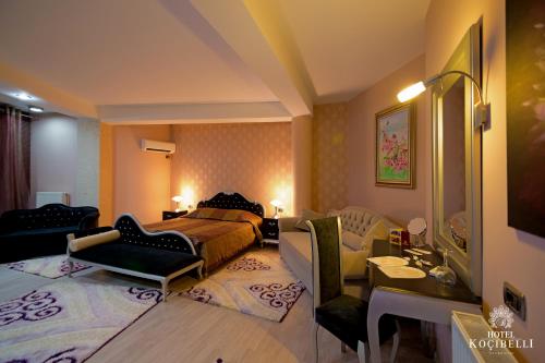 a bedroom with a bed and a living room at Hotel Kocibelli POOL & SPA in Korçë