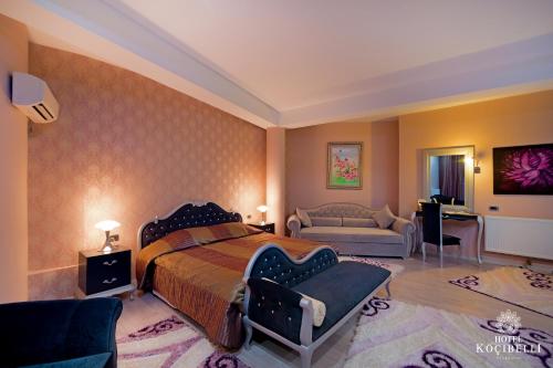 a bedroom with a king sized bed and a couch at Hotel Kocibelli POOL & SPA in Korçë