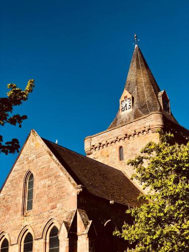 a church with a tower with a clock on it at Albatross B&B Dornoch in Dornoch