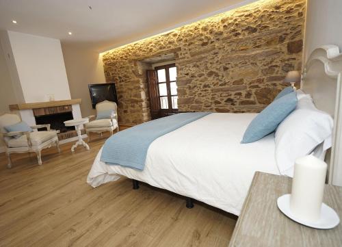 a bedroom with a bed and a stone wall at Casa Rural La Villa de Tábara in Tábara