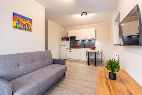 a living room with a couch and a table and a kitchen at Wczasowa 8 Apartments in Sarbinowo