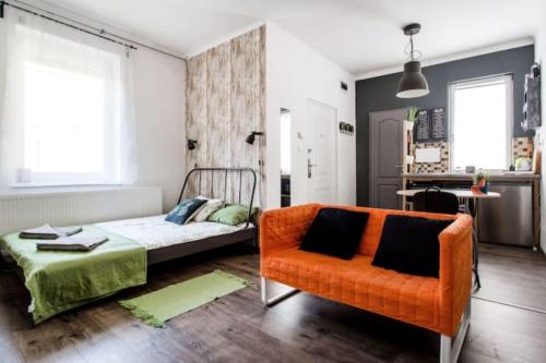 - une chambre avec un lit et une chaise orange dans l'établissement BpR Colorist Apartments, à Budapest