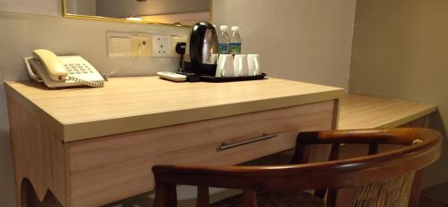 a desk with a phone and a coffee maker on it at Prima Hotel Melaka in Melaka