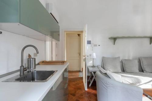 a kitchen with a sink and a couch in a room at Bilocale nel Parco di Villa Erba in Cernobbio