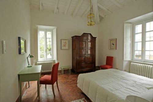 a bedroom with a bed and a desk and two chairs at Bilocale nel Parco di Villa Erba in Cernobbio