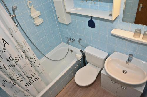 a blue bathroom with a toilet and a sink at BRN Seemoewe in Laboe