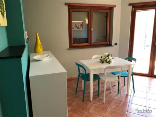 a kitchen with a table and chairs and a white table and a white table at Casa vacanze “Perla del Circeo” in Sabaudia