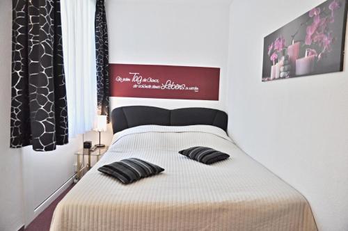 um quarto com uma cama com duas almofadas pretas em SH 48 Ostseeoase em Laboe