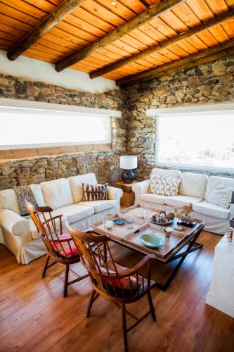 a living room with a table and a stone wall at Casa dos Castelejos in Guerreiro