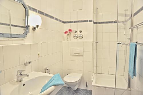 ein Bad mit einem WC, einem Waschbecken und einer Dusche in der Unterkunft Villa Fördestrand - "Sehpferdchen" in Laboe