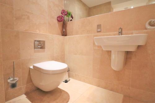 a bathroom with a toilet and a sink at BEACHSIDE SPACIOUS apartment, private garden in Saint Merryn