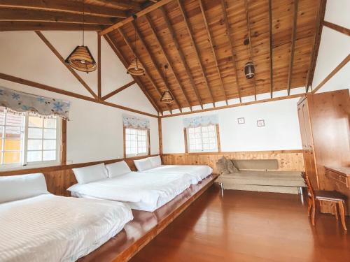 een kamer met twee bedden en een bank erin bij Euro Country Villa in Renai
