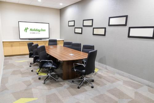 a conference room with a wooden table and chairs at Holiday Inn Hattiesburg - North by IHG in Hattiesburg