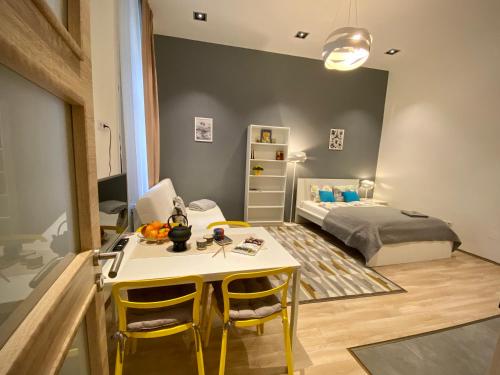 Cette petite chambre comprend un lit, une table et des chaises. dans l'établissement GRACIA APARTMENT HOUSE, à Budapest