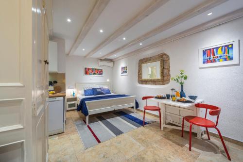 a bedroom with a bed and a table and two red chairs at Apartment Neva in Dubrovnik