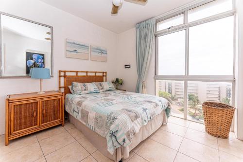 a bedroom with a bed and a large window at Amazing Sea View Apartment La Ballito in Ballito