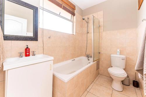 a bathroom with a tub and a toilet and a sink at Amazing Sea View Apartment La Ballito in Ballito