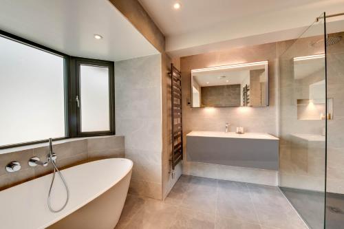 uma casa de banho com uma banheira e um lavatório em Cleabarrow Cottage em Windermere