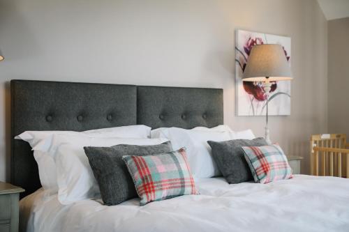 białe łóżko z poduszkami i lampą w obiekcie Cherry Trees w mieście Windermere