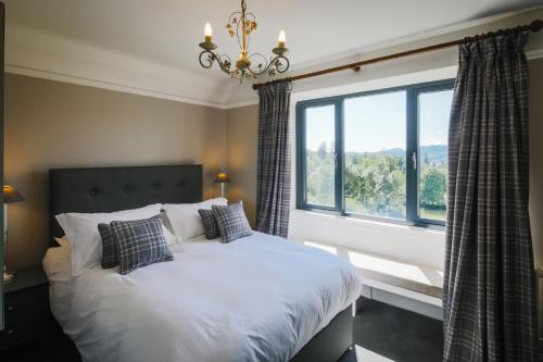 a bedroom with a bed and a large window at Cherry Trees in Windermere