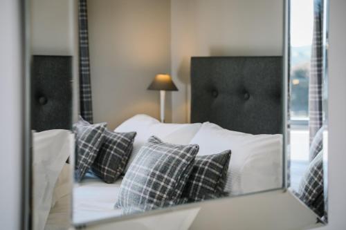 a reflection of a bed with pillows in a mirror at Cherry Trees in Windermere