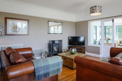 a living room with two couches and a tv at Cherry Trees in Windermere