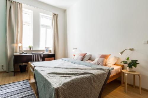 1 dormitorio con cama, escritorio y ventana en Apartment Jeseniova en Praga