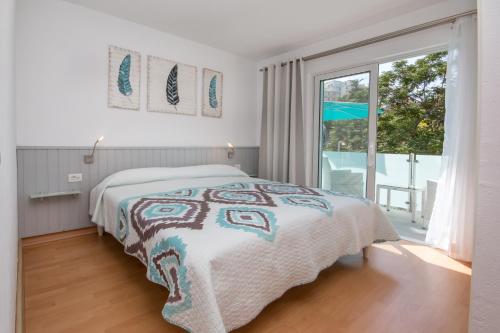 a bedroom with a bed and a large window at CasaColores Apartamentos in Puerto de la Cruz
