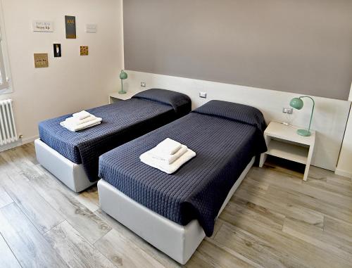 zwei Betten in einem Zimmer mit blauen Laken in der Unterkunft Bianca Room & Breakfast in Bologna