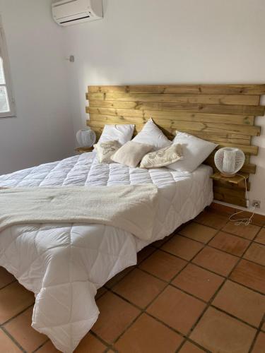 a bedroom with a large bed with a wooden headboard at Villa Louise in Sainte-Rose