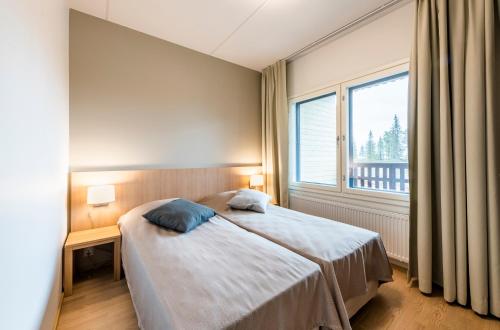 a bedroom with a bed and a large window at Ruka Ski Chalets in Ruka