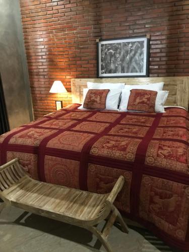 a bedroom with a large bed and a chair at D'Rus Hill munduk in Singaraja