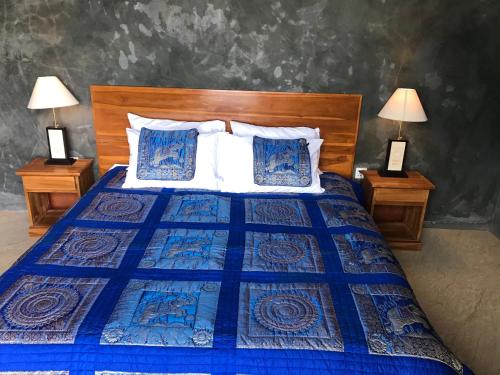 a bedroom with a blue bed with two night stands at D'Rus Hill munduk in Singaraja