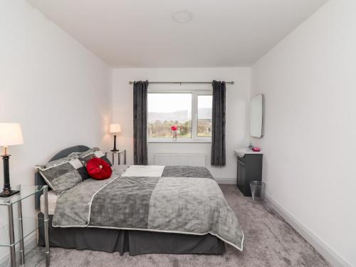 a bedroom with a bed and a window at Coolnaharragill Lower in Killarney