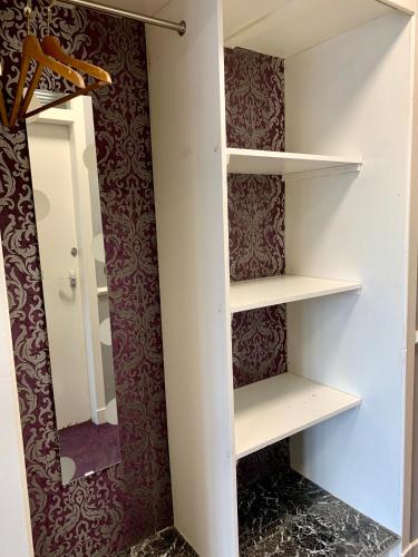 a walk in closet with white shelves and a mirror at Northumberland Hotel in Edinburgh