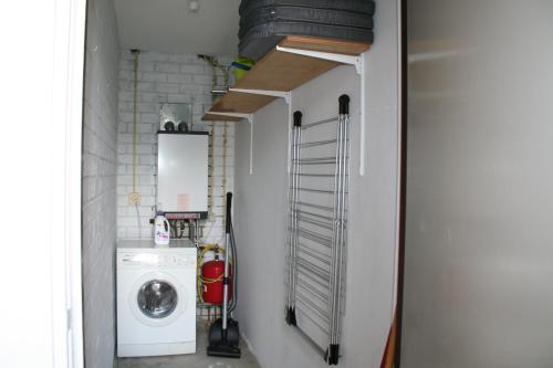 een kleine wasruimte met een wasmachine en droger bij Schorrebloem 10 in Nieuwvliet