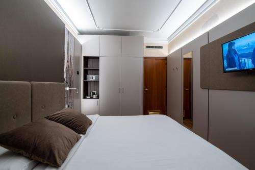 a bedroom with a bed with a tv on the wall at Hotel Mythos in Milan