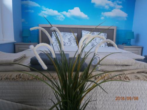 a bedroom with a bed with white flowers on it at Sloneczna 10tka in Sztutowo